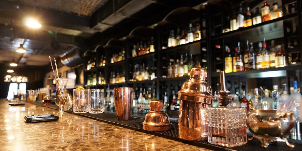 Classic bar counter with bottles in blurred background